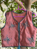 Front view of dusty rose butterfly embellished vest with teal trim and tassel ties